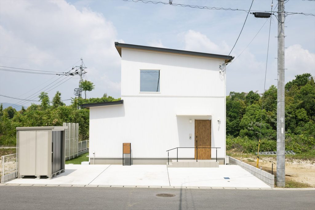 屋外に倉庫のあるガルバリウム鋼板の白い家